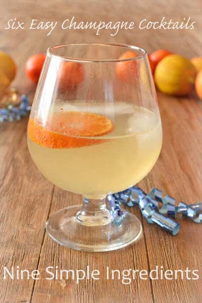 Glass of a light colored sparkling drink with an orange slice and ice.