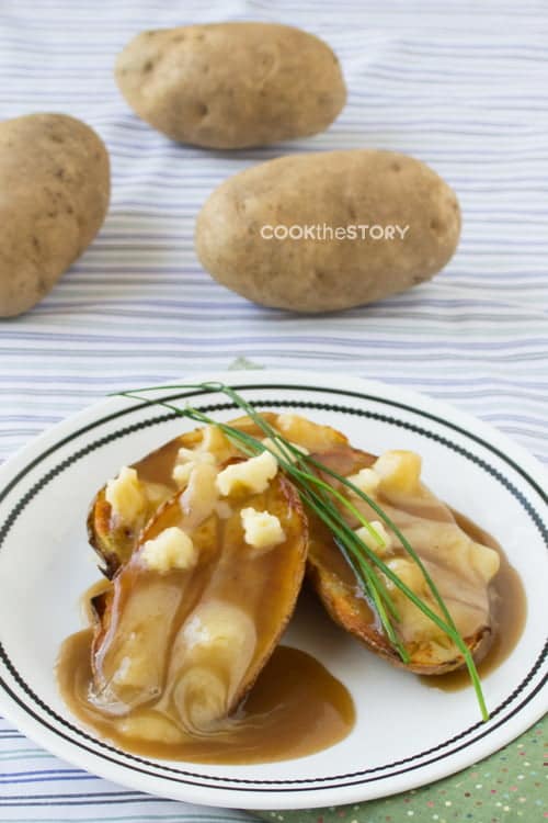 Lazy Poutine made with baked potatoes, cheese, and bottled gravy on a white plate.