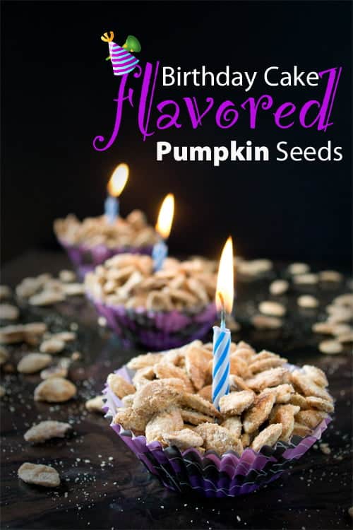 Birthday Cake Flavored Roasted Pumpkin Seeds in cupcake liners with birthday candles lit in the center.