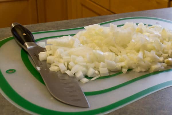 Diced onion on a board with knife.