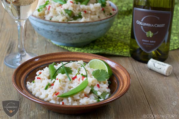 Asian Oven Risotto in a brown bowl, serving bowl and white wine in background.