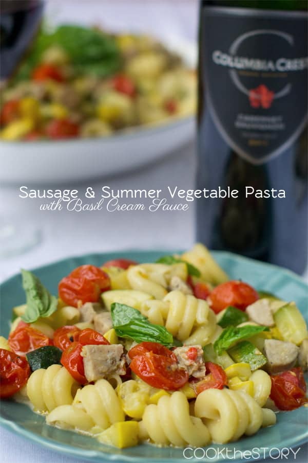 Sausage & Summer Vegetable Pasta with Basil Cream Sauce on a blue plate.