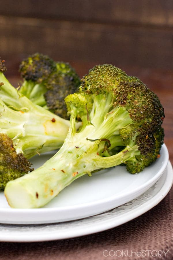 Oven Roasted Broccoli, browned and tender, on a white plate.