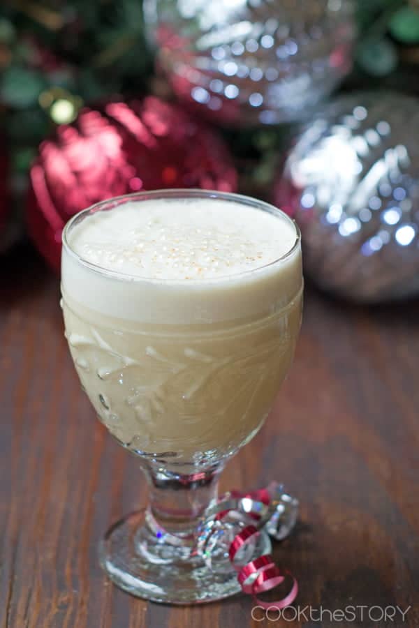 Light Eggnog in a glass with grated nutmeg on top.