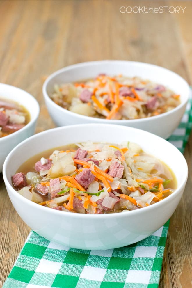 White bowls with corned beef and cabbage soup.