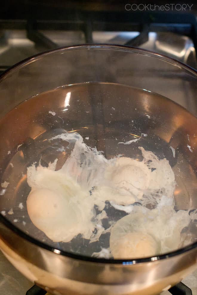 Eggs poaching in the simmering water.