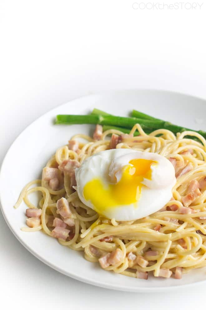 Spaghetti with diced ham and topped with a poached egg, asparagus on the side.